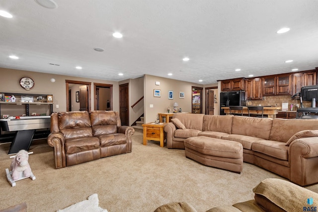 living area featuring carpet floors, recessed lighting, and stairs