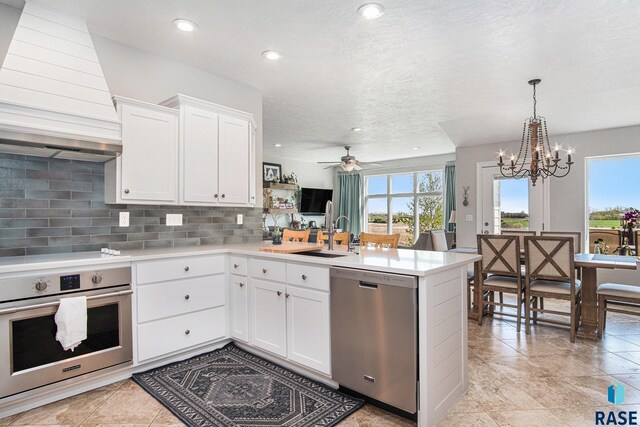 46370 237th St, Wentworth, SD 57075 - kitchen featuring stainless steel appliances, custom range hood, a sink, a peninsula, and backsplash