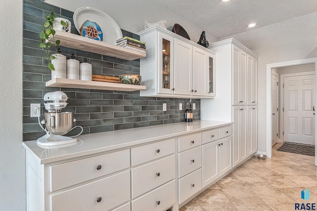46370 237th St, Wentworth, SD 57075 - kitchen with open shelves, backsplash, white cabinetry, light countertops, and glass insert cabinets