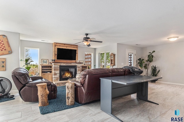 46370 237th St, Wentworth, SD 57075 - living area featuring a stone fireplace, healthy amount of natural light, ceiling fan, and baseboards