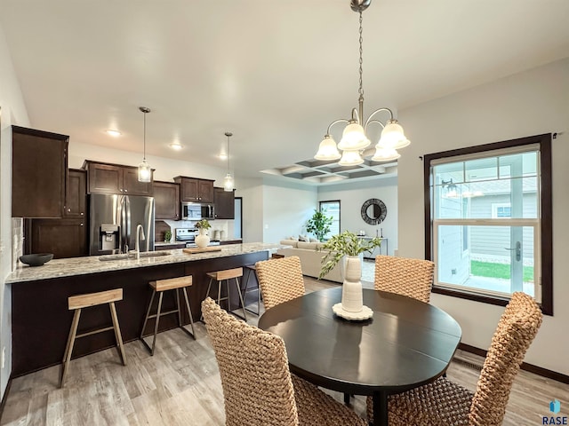8612 W Dalton St, Sioux Falls, SD 57106 - dining space with light wood-style floors, a chandelier, and baseboards