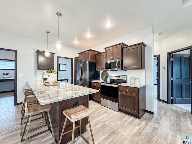 8612 W Dalton St, Sioux Falls, SD 57106 - kitchen featuring stainless steel appliances, dark brown cabinetry, a kitchen breakfast bar, light wood finished floors, and a peninsula