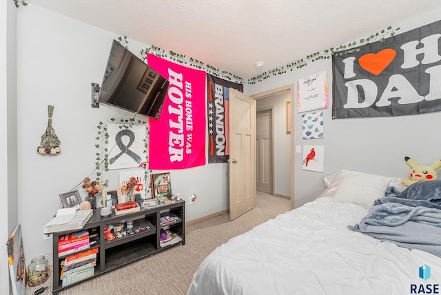 carpeted bedroom featuring baseboards and a textured ceiling
