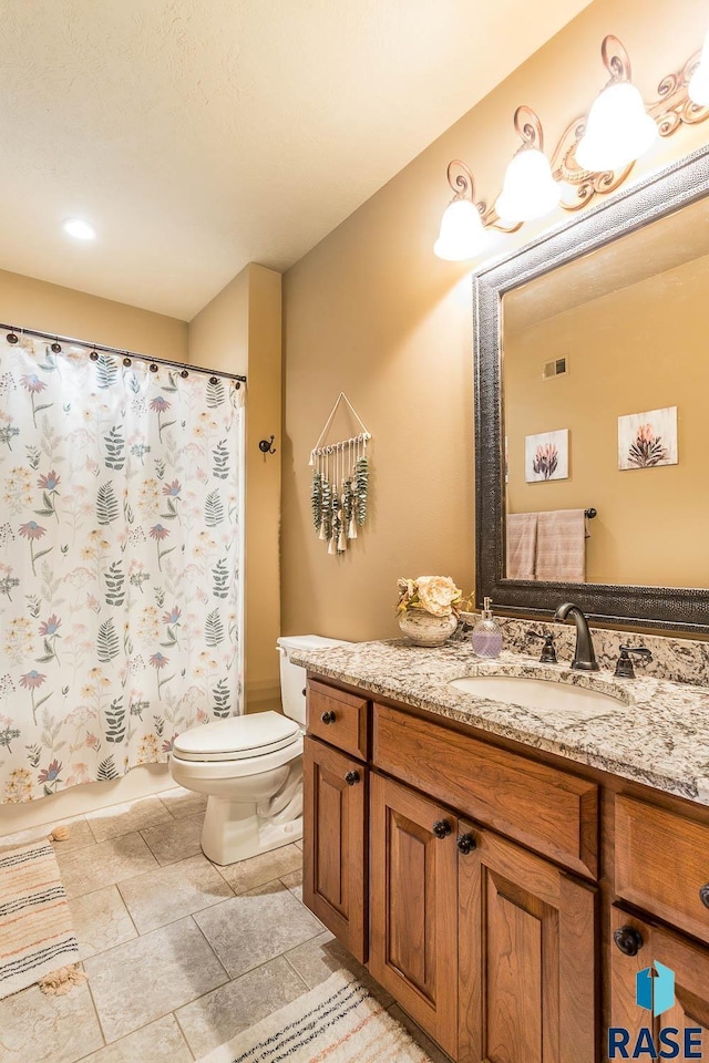 bathroom with toilet, vanity, a shower with shower curtain, and tile patterned flooring