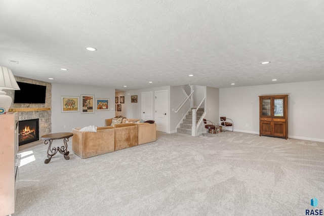 living area with stairway, light carpet, a stone fireplace, recessed lighting, and baseboards