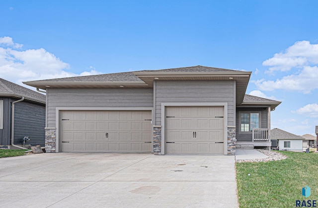 2629 S Richie Dr, Sioux Falls, SD 57106 - view of front of property with an attached garage, concrete driveway, stone siding, and a shingled roof