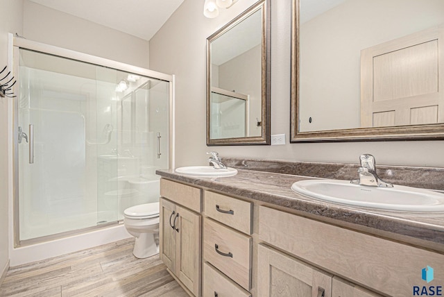 2629 S Richie Dr, Sioux Falls, SD 57106 - full bath with a stall shower, wood finished floors, toilet, and double vanity