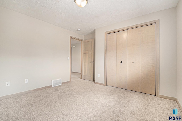 2629 S Richie Dr, Sioux Falls, SD 57106 - unfurnished bedroom featuring carpet flooring, a closet, baseboards, and a textured ceiling