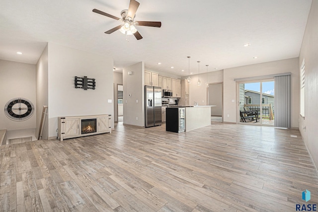 2629 S Richie Dr, Sioux Falls, SD 57106 - unfurnished living room featuring light wood finished floors, ceiling fan, a glass covered fireplace, recessed lighting, and baseboards