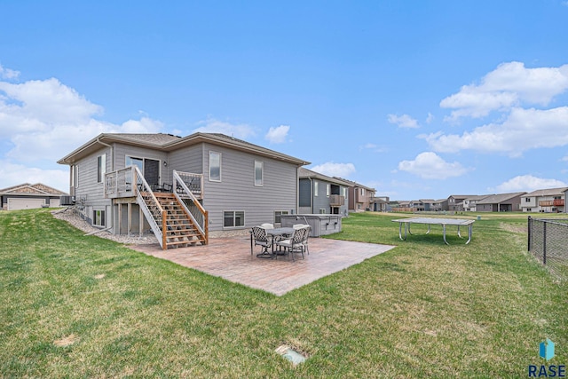 2629 S Richie Dr, Sioux Falls, SD 57106 - back of property with a trampoline, stairs, a patio area, and a wooden deck