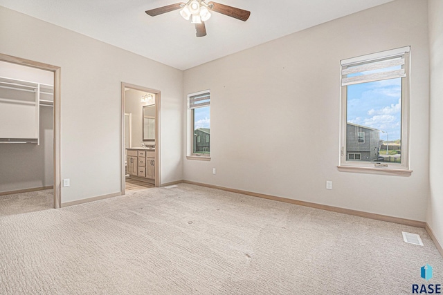2629 S Richie Dr, Sioux Falls, SD 57106 - unfurnished bedroom with light colored carpet, baseboards, and a walk in closet