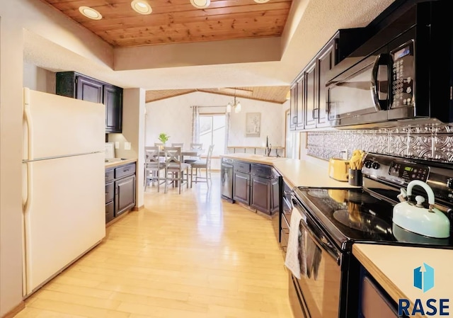 2304 S Mockingbird Cir, Sioux Falls, SD 57103 - kitchen with black appliances, wood ceiling, light wood-style flooring, light countertops, and a tray ceiling
