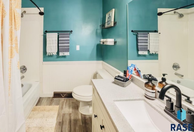 2304 S Mockingbird Cir, Sioux Falls, SD 57103 - full bathroom with wood finished floors, shower / bath combo, vanity, toilet, and wainscoting