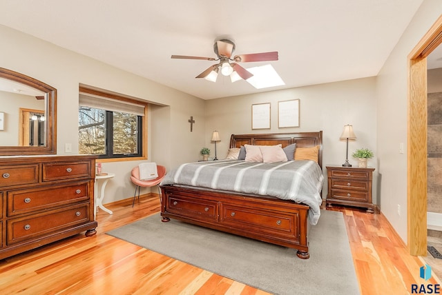 408 N Oak Ridge Rd, Brandon, SD 57005 - bedroom featuring a skylight, light wood finished floors, baseboards, and ceiling fan