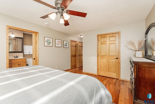 408 N Oak Ridge Rd, Brandon, SD 57005 - bedroom featuring light wood-style floors, connected bathroom, a sink, ceiling fan, and baseboards