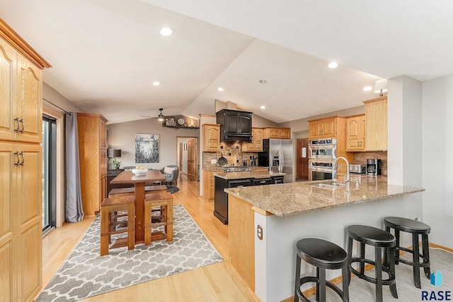 408 N Oak Ridge Rd, Brandon, SD 57005 - kitchen with appliances with stainless steel finishes, light wood-style flooring, vaulted ceiling, decorative backsplash, and a peninsula