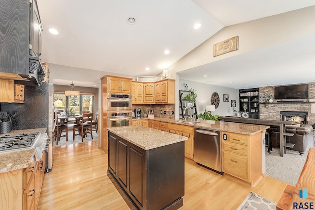 408 N Oak Ridge Rd, Brandon, SD 57005 - kitchen with appliances with stainless steel finishes, a peninsula, a sink, open floor plan, and light wood-type flooring