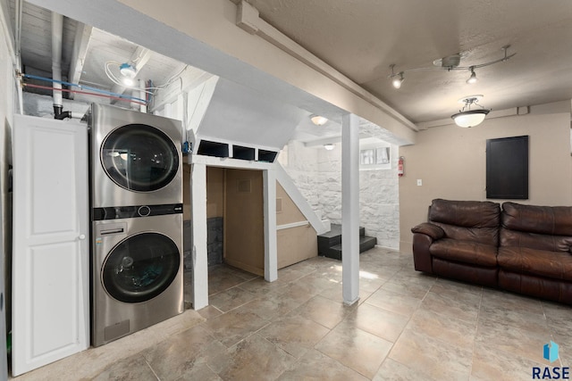 clothes washing area featuring stacked washer / dryer