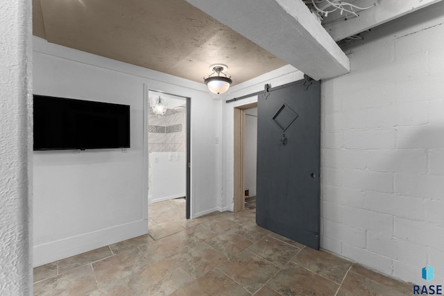 spare room featuring a barn door and stone finish flooring