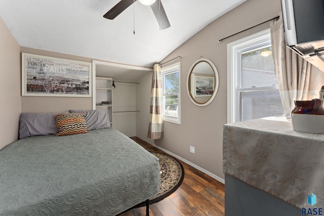 bedroom with vaulted ceiling, dark wood-style floors, baseboards, and a ceiling fan