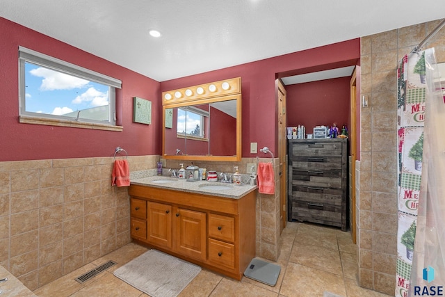 31780 476th Ave, Elk Point, SD 57025 - bathroom featuring tile walls, tile patterned floors, beverage cooler, double vanity, and wainscoting