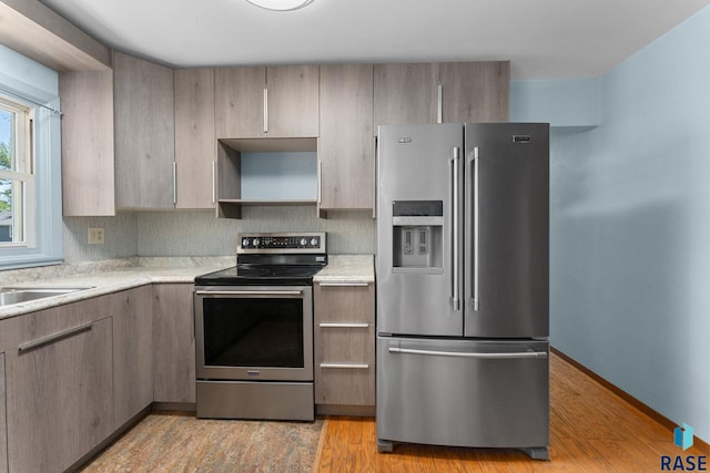 1712 S Bruce Rd, Sioux Falls, SD 57105 - kitchen featuring appliances with stainless steel finishes, light countertops, open shelves, and light wood-style flooring