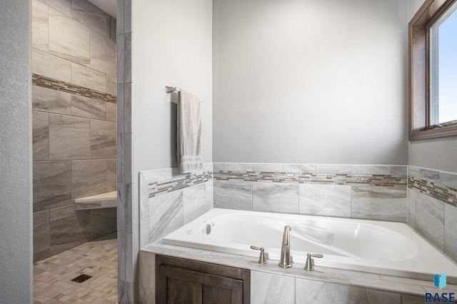 full bathroom with a bath and a tile shower