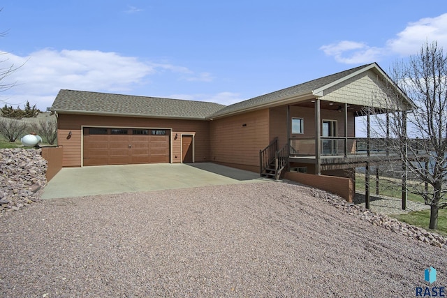 view of front of home featuring gravel driveway, a garage, and ceiling fan
