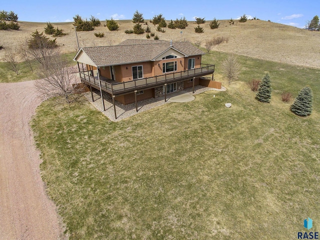 rear view of property featuring a wooden deck, a rural view, and a yard