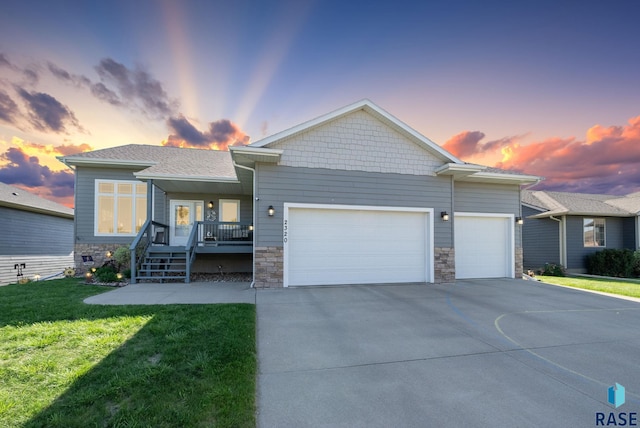 2320 N Ivy Rd, Tea, SD 57064 - view of front of property featuring a garage, driveway, a front lawn, covered porch, and stone siding