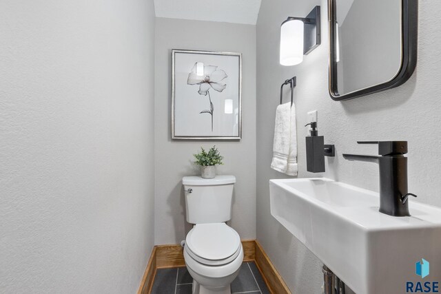 705 E 21st St, Sioux Falls, SD 57105 - half bathroom featuring a sink, tile patterned flooring, toilet, and baseboards
