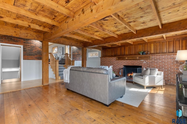705 E 21st St, Sioux Falls, SD 57105 - living area featuring light wood-style floors, stairway, a fireplace, brick wall, and wood ceiling with exposed beams