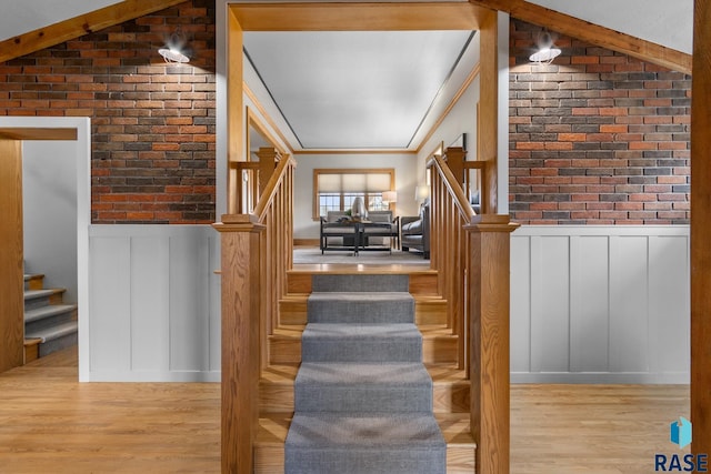 705 E 21st St, Sioux Falls, SD 57105 - staircase with a decorative wall, brick wall, wainscoting, and wood finished floors