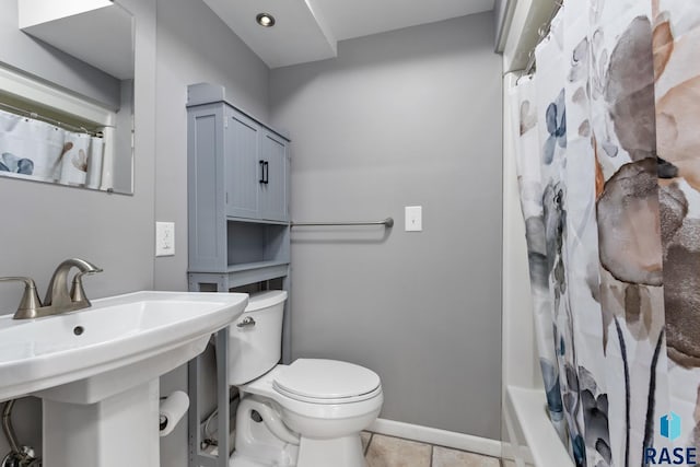 705 E 21st St, Sioux Falls, SD 57105 - bathroom with toilet, tile patterned floors, a sink, shower / bath combo with shower curtain, and baseboards