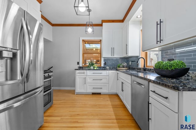 705 E 21st St, Sioux Falls, SD 57105 - kitchen featuring appliances with stainless steel finishes, a sink, light wood-style floors, crown molding, and backsplash