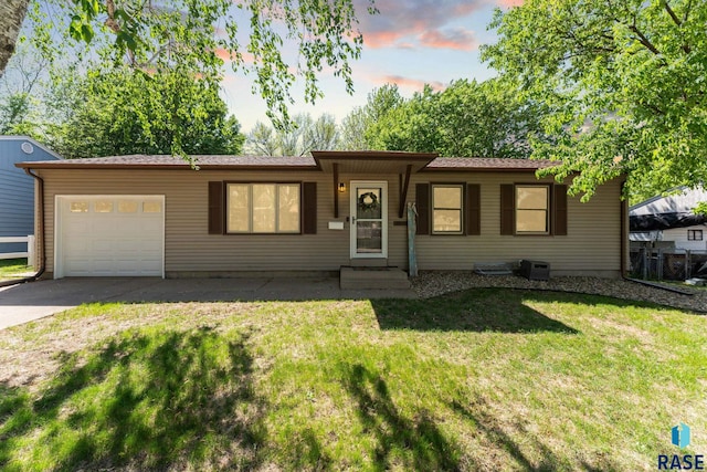 ranch-style home with an attached garage, driveway, a front yard, and central AC