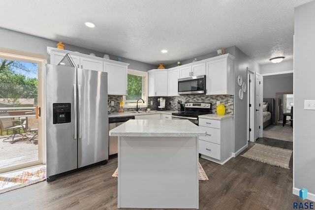 kitchen featuring appliances with stainless steel finishes, tasteful backsplash, light countertops, white cabinets, and dark wood-style flooring