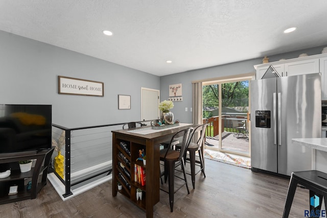 dining room featuring dark wood finished floors, recessed lighting, and a textured ceiling