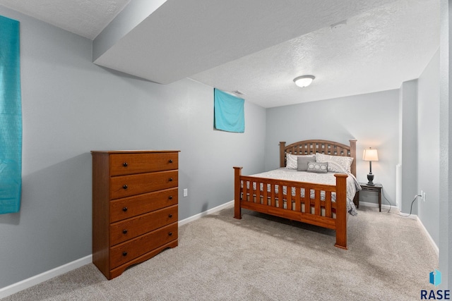 carpeted bedroom featuring a textured ceiling and baseboards