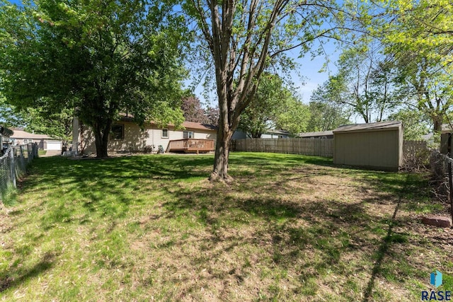 view of yard featuring a wooden deck, an outdoor structure, and a storage shed