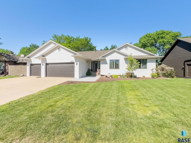 ranch-style home with a garage, driveway, and a front yard
