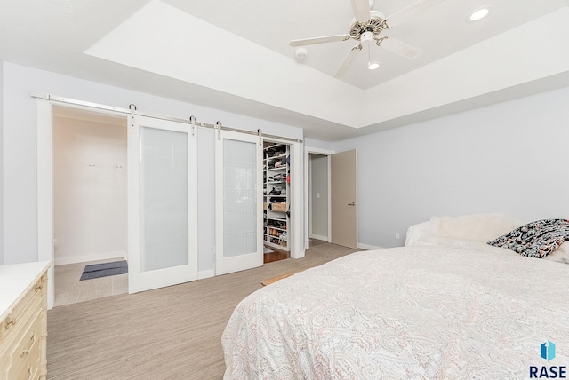 bedroom featuring recessed lighting, a barn door, light carpet, baseboards, and ceiling fan