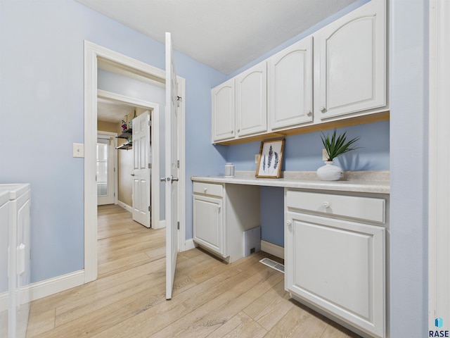48288 Arrowhead Ct, Canton, SD 57013 - laundry area with light wood finished floors, baseboards, and cabinet space
