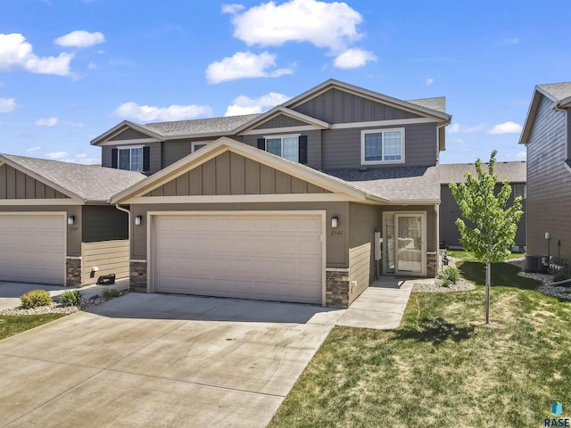 2541 E Meadowside Pl, Sioux Falls, SD 57108 - view of front of home featuring board and batten siding, stone siding, roof with shingles, and driveway
