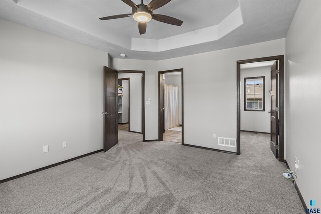 2541 E Meadowside Pl, Sioux Falls, SD 57108 - unfurnished bedroom with light colored carpet, baseboards, a tray ceiling, and ceiling fan