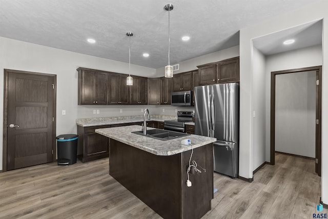 2541 E Meadowside Pl, Sioux Falls, SD 57108 - kitchen with appliances with stainless steel finishes, a sink, dark brown cabinetry, light wood finished floors, and decorative light fixtures