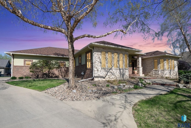 view of front of house with brick siding and a front lawn