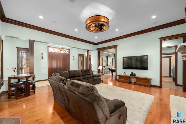 living area featuring ornate columns, crown molding, light wood-type flooring, baseboards, and recessed lighting