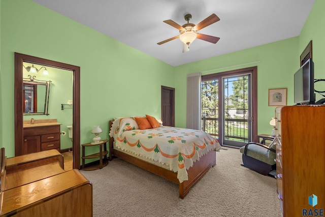 bedroom featuring access to outside, light colored carpet, ensuite bath, a ceiling fan, and a sink
