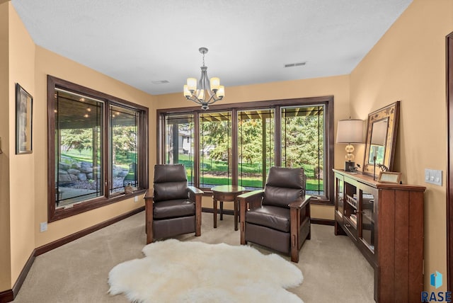 sitting room with light carpet, a chandelier, and baseboards